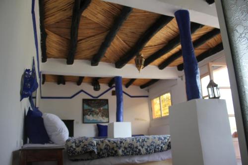a room with a bed and a wooden ceiling at Kasbah de Ouirgane in Ouirgane