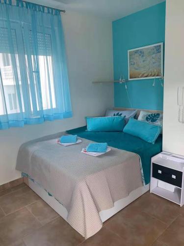 a blue bedroom with a large bed with blue pillows at Apartment Stella Maris in Herceg-Novi