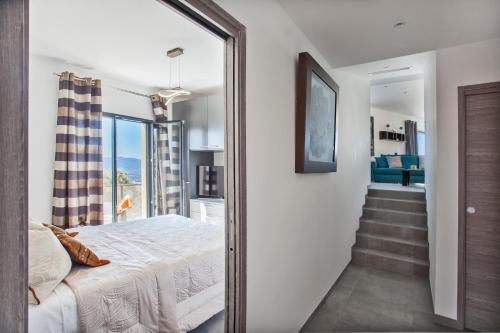 1 dormitorio con 1 cama y un pasillo con una escalera. en Villa No Stress Aria di Petra, en Olmeto