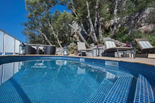 une piscine avec deux chaises longues à côté dans l'établissement Villa No Stress Aria di Petra, à Olmeto