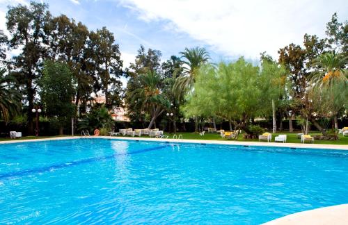 a large swimming pool in a resort with trees at Intelier Orange in Benicàssim