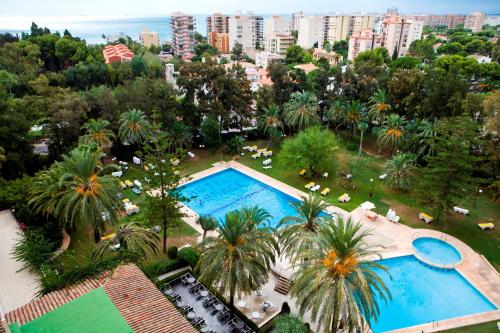 an overhead view of a pool with palm trees and buildings at Intelier Orange in Benicàssim