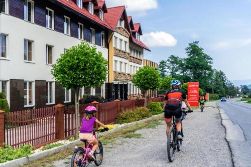 un grupo de personas montando bicicletas por una calle en Gronie Ski & Bike, en Szczyrk