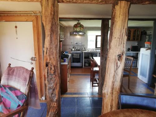 a kitchen and dining room with wooden beams at Casa Rural Huillinco in Huillinco