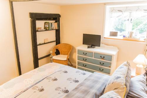 Mayfield的住宿－Rose and Crown，一间卧室配有一张床、一个梳妆台和一扇窗户。