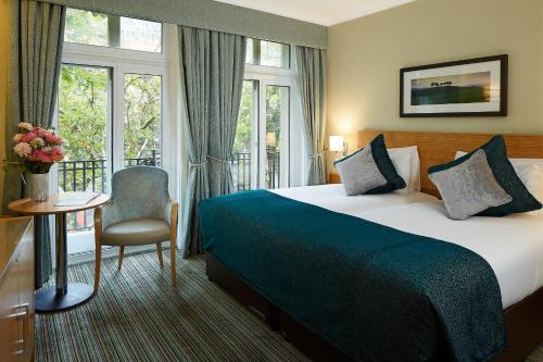 um quarto de hotel com uma cama e uma janela em The Rembrandt em Londres