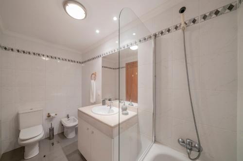a bathroom with a shower and a sink and a toilet at Ilhéus IV by An Island Apart in Funchal