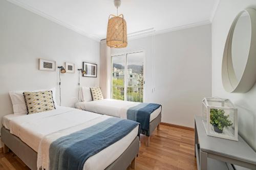 a hotel room with two beds and a mirror at Ilhéus IV by An Island Apart in Funchal