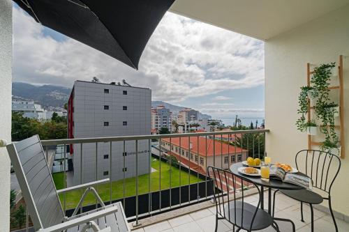 a balcony with a table and chairs and a view at Ilhéus IV by An Island Apart in Funchal