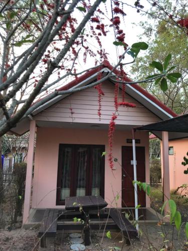 a pink house with a picnic table in front of it at Green Leaf Resort in Surin