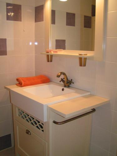 une salle de bain blanche avec un lavabo et un miroir dans l'établissement Au Bord de Sèvre, à Coulon