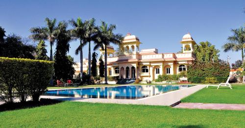a large house with a swimming pool in front of it at jüSTa Rajputana Resort & Convention Centre, Udaipur in Udaipur