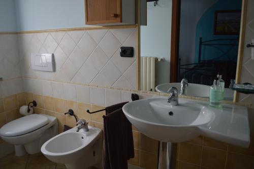 a bathroom with two sinks and a toilet at Tra... Monti E Vigne in La Morra