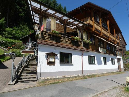 ein Gebäude mit einem Balkon mit Blumen darauf in der Unterkunft Pension Holzerstube in Beerfelden