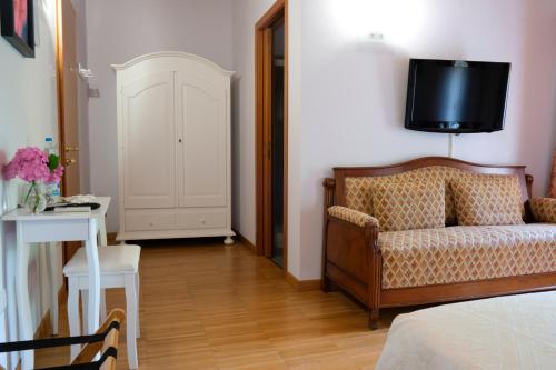 a living room with a couch and a tv on the wall at B&B in Valle in Lumignano