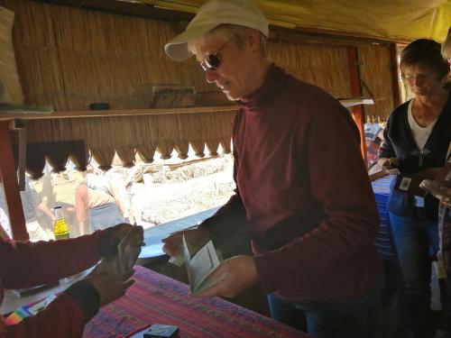 a woman is giving a box to a person at Urosfood & Titiqaqa Lodge in Uros