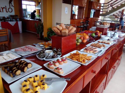 a buffet with many plates of food on a table at Hotel Centenario in Puerto Maldonado