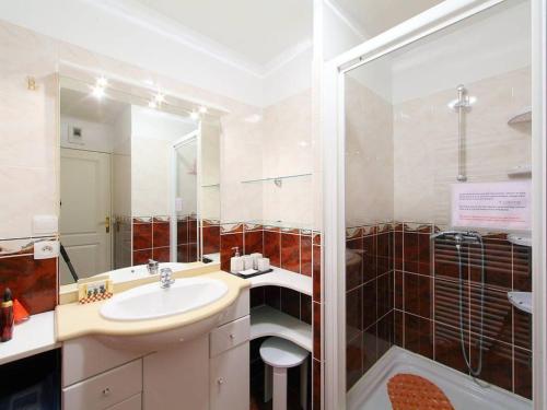 a white bathroom with a sink and a shower at LE PATIO in Canet-en-Roussillon
