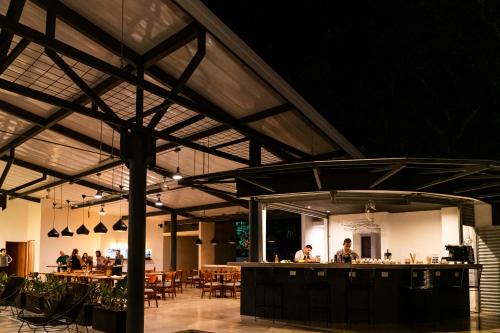 un restaurante con un bar con gente sentada en las mesas en Hotel Nya, en Montezuma