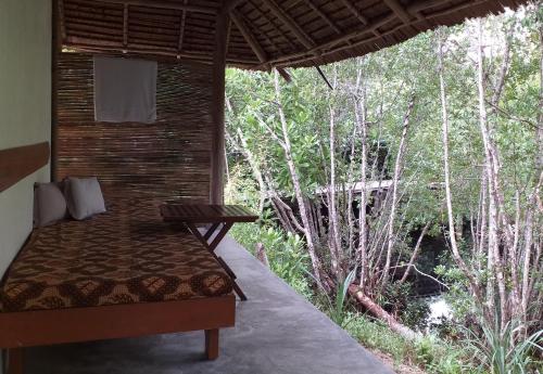 a bed in a room with a view of a river at Mutiara Beach Resort in Berakit