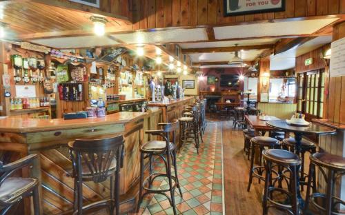 eine Bar mit Holzwänden und Hockern in einem Restaurant in der Unterkunft Hotel Curracloe in Curracloe