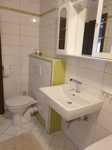 a white bathroom with a sink and a toilet at Villa Grossglockner Heiligenblut in Heiligenblut