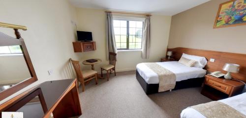 a hotel room with two beds and a window at Hotel Curracloe in Curracloe