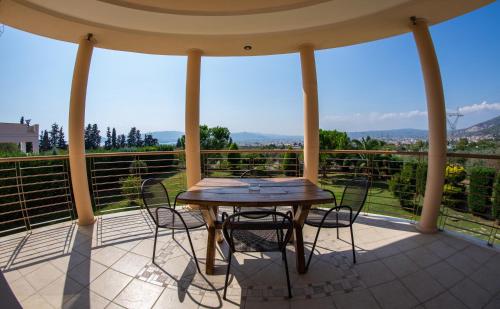 a table and chairs on a porch with a view at Luxury Villa Thea in Volos