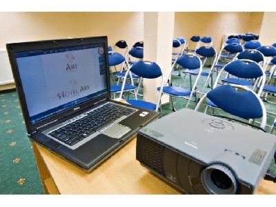 a laptop computer sitting on a table in a room with chairs at Hotel Ary in Cluj-Napoca