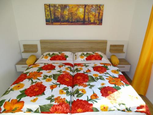 a bed with a flowered comforter on it at Ferienwohnung Hofstatt in Lalling