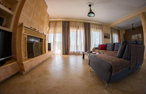 a living room with a couch and a tv at Luxury Villa Thea in Volos