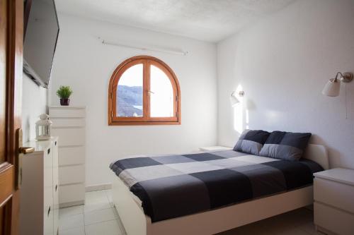 a bedroom with a black and white bed and a window at Sunshine Miami Beach in Mogán