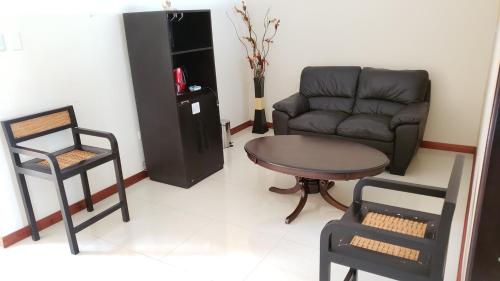 a living room with a couch and a table and chair at Hotel Centenario in Puerto Maldonado