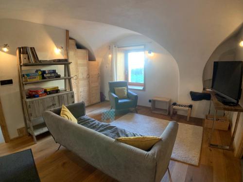 een woonkamer met een bank en een tv bij Le Gabion, luxueux appartement avec sauna, Serre chevalier Vallée in Saint-Chaffrey
