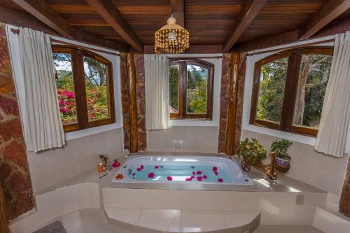 a bath tub in a room with windows at Castelar da Alvorada in Vale do Capao