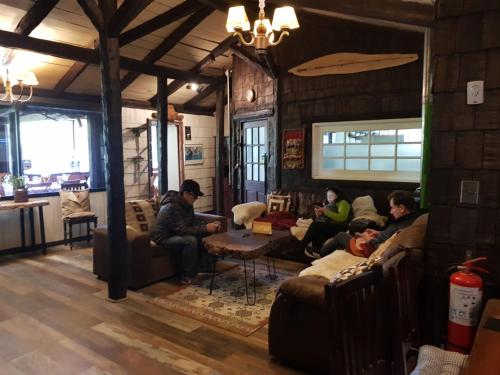 a group of people sitting on couches in a room at The Patagonian Lodge in Coihaique