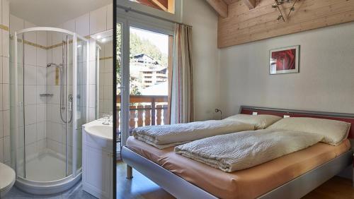a bedroom with a bed and a shower and a bathroom at Château A&B in Saas-Fee