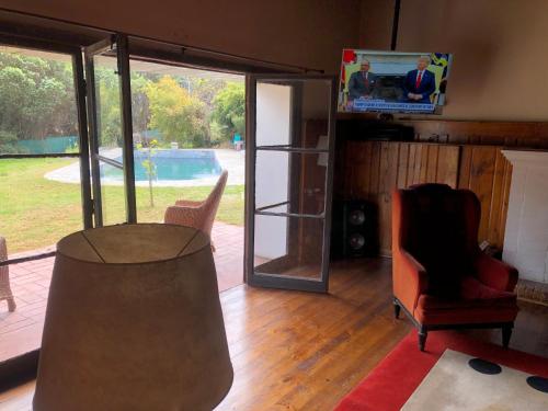 a living room with a tv and a couch and chairs at The White House by Casona Lo Aguirre - El Monte RM in Talagante