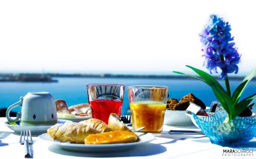 a table topped with plates of food and drinks at Hotel Al Faro in Licata