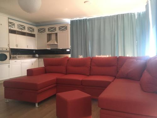 a living room with a red couch and a kitchen at Hotel Black Horse in Prešov
