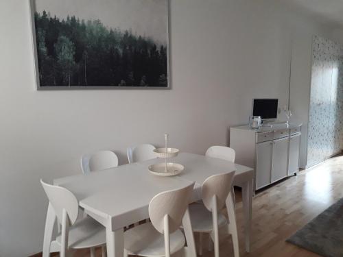 - une salle à manger blanche avec une table et des chaises blanches dans l'établissement Ypsibloom, à Castelbuono
