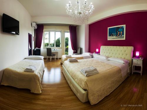 1 dormitorio con 2 camas y pared de color rosa en Metropolis B&B, en Messina