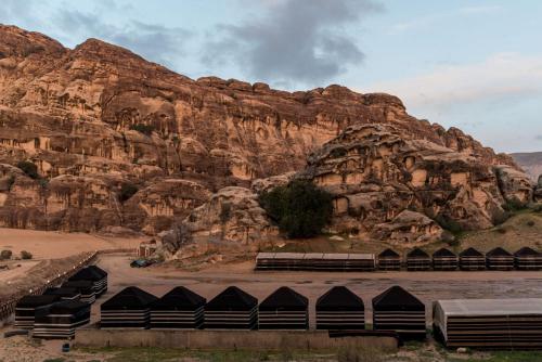 a group of tents in front of a mountain at Ammarin Bedouin Camp in Wadi Musa