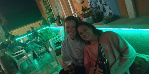 two women sitting next to each other in a room at Minka Hostel in Quito