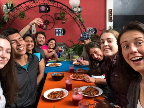 a group of people sitting at a table eating food at Minka Hostel in Quito