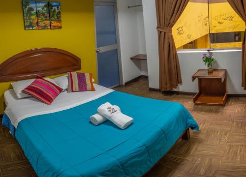 a bedroom with a bed with two towels on it at Tupac Lima Airport in Lima