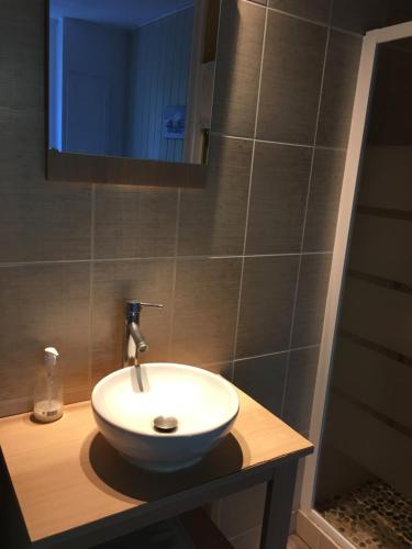 uma casa de banho com um lavatório branco e um espelho. em chambre double avec salle de bain privative em Cognac