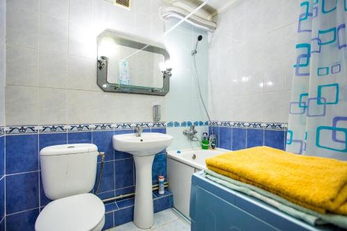 baño azul y blanco con lavabo y aseo en Квартира на Соборной, en Mykolaiv