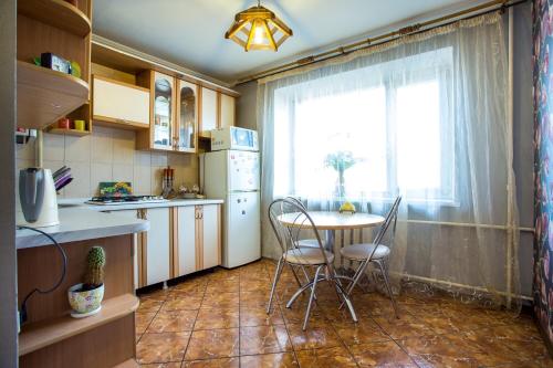 cocina con mesa, sillas y ventana en Квартира на Соборной, en Mykolaiv