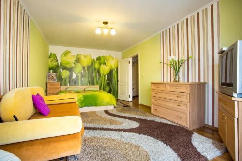 1 dormitorio con 1 cama, TV y sofá en Квартира на Соборной, en Mykolaiv